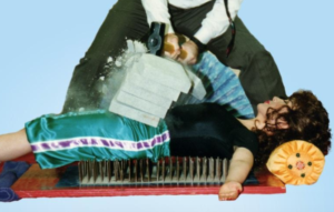 Tae Yun Kim on a bed of nails while cement is crushed in half on her